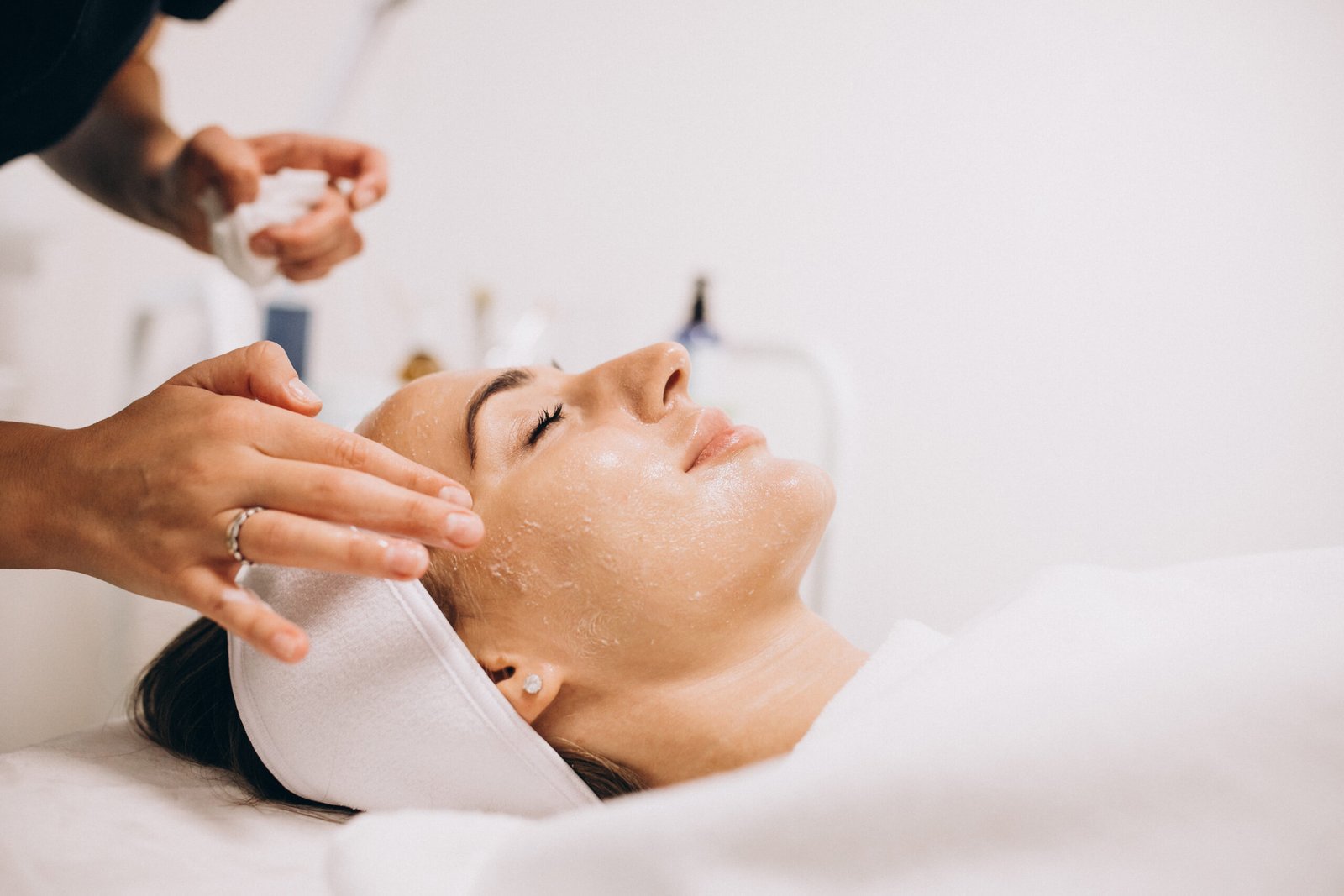 Cosmetologist cleaning face of a woman in a beauty salon Cosmetologist cleaning face of a woman in a beauty salon